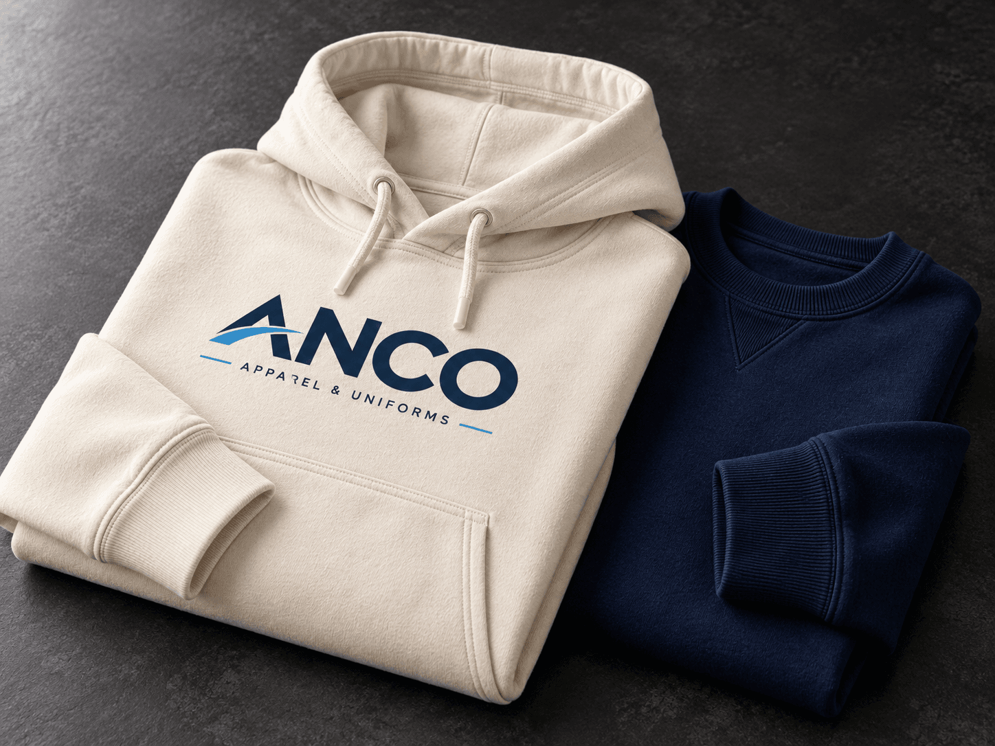ANCO cream hoodie and navy crewneck folded together